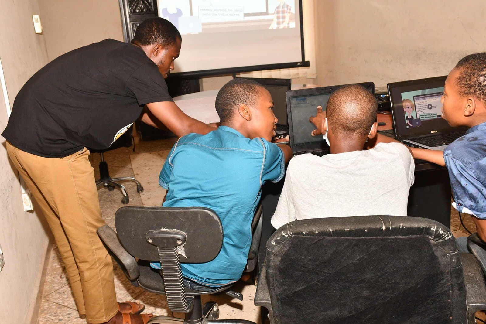 A mentor guiding students during a Coding With Friends computer session
